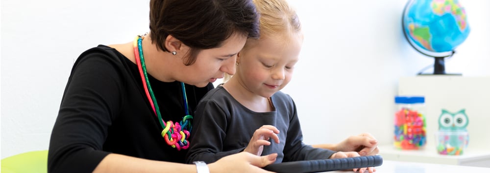 therapist scoring child on tablet